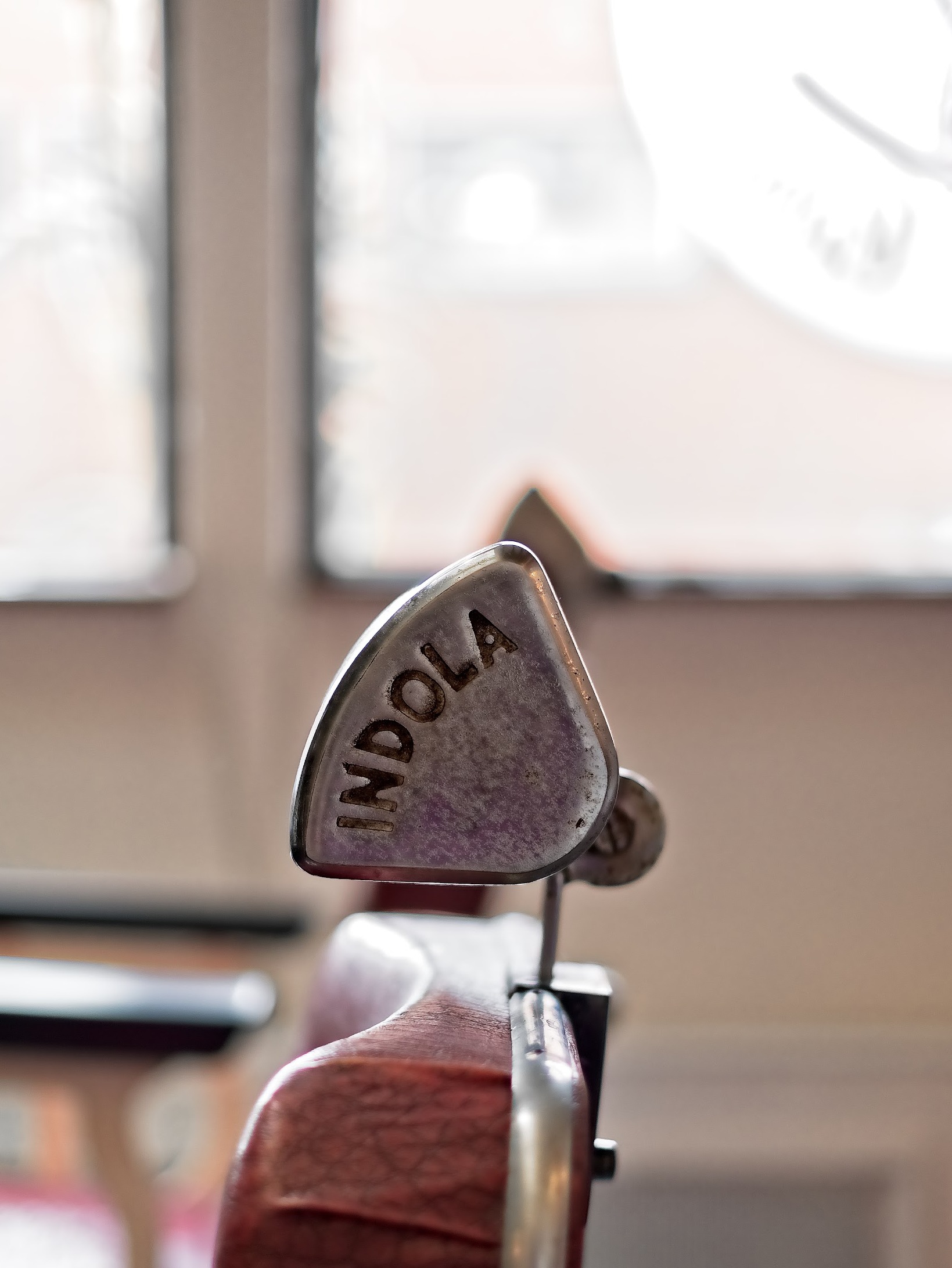 Hoofdsteun van een vintage Indola-kappersstoel voor het raam