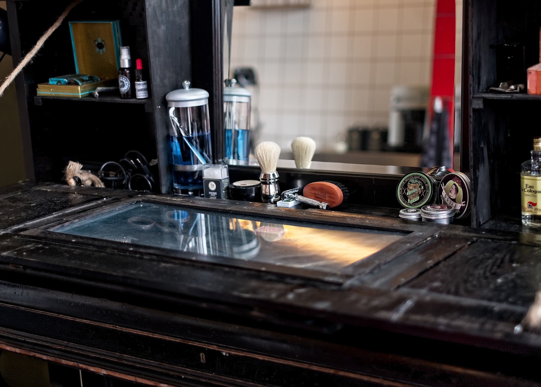 De zwarte werkbank van The Bodhi Barber met scheerkwasten, potten en de spiegel